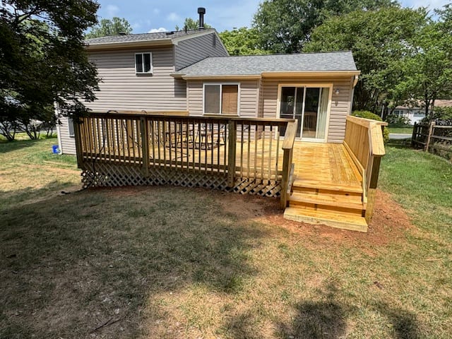 Finished raised backyard deck with timber railings and stairs leading to the lawn.